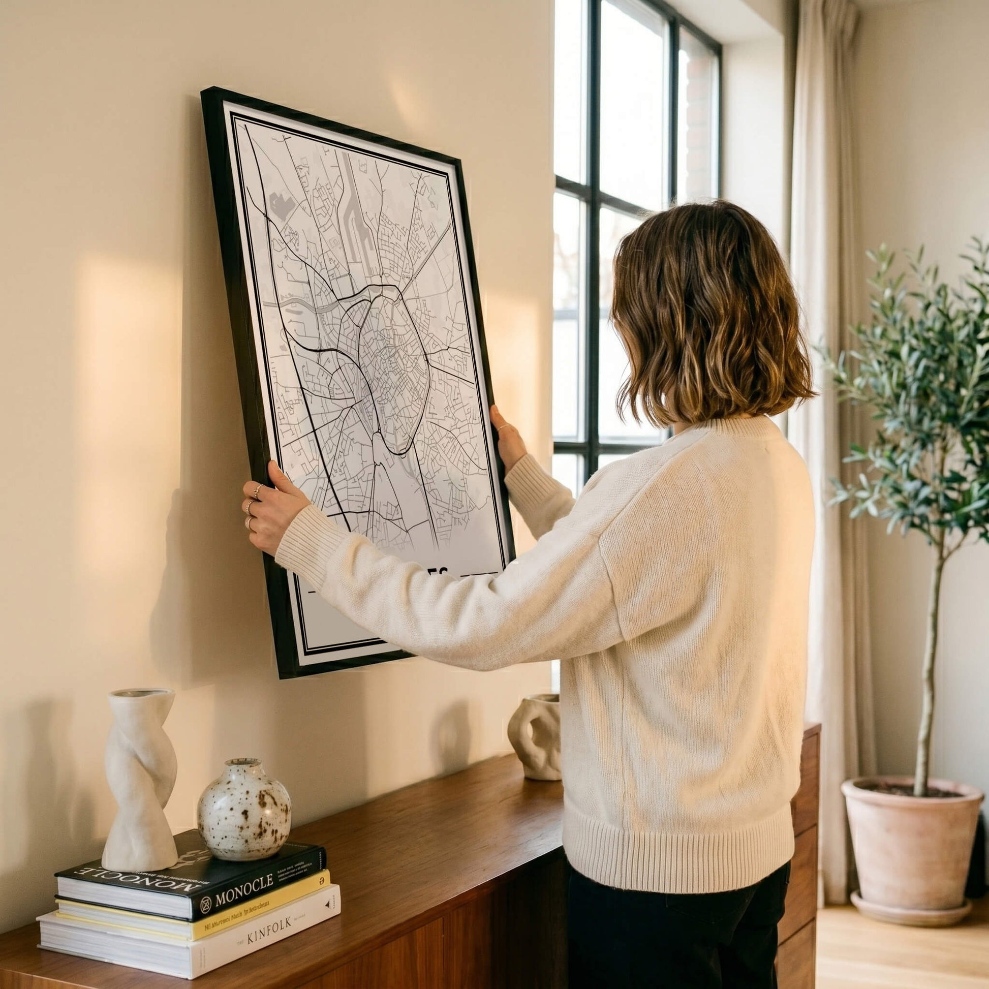 Brugge Stadskaart – Poster - Vrouw hangt wanddecoratie op