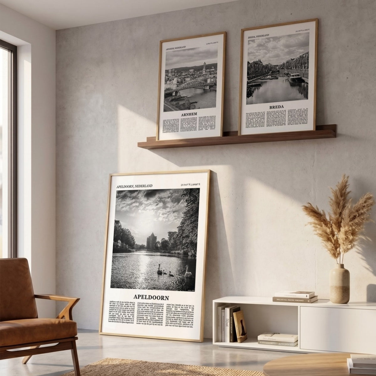 Drie ingelijste posters boven de bank in de woonkamer met Apeldoorn Fotoposter – Zwart-Wit in het groot