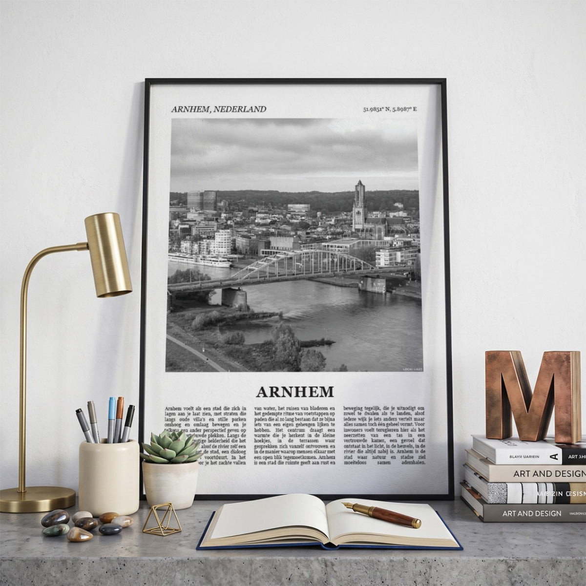 Ingelijste Arnhem Fotoposter – Zwart-Wit op een bureau in zwarte fotolijst