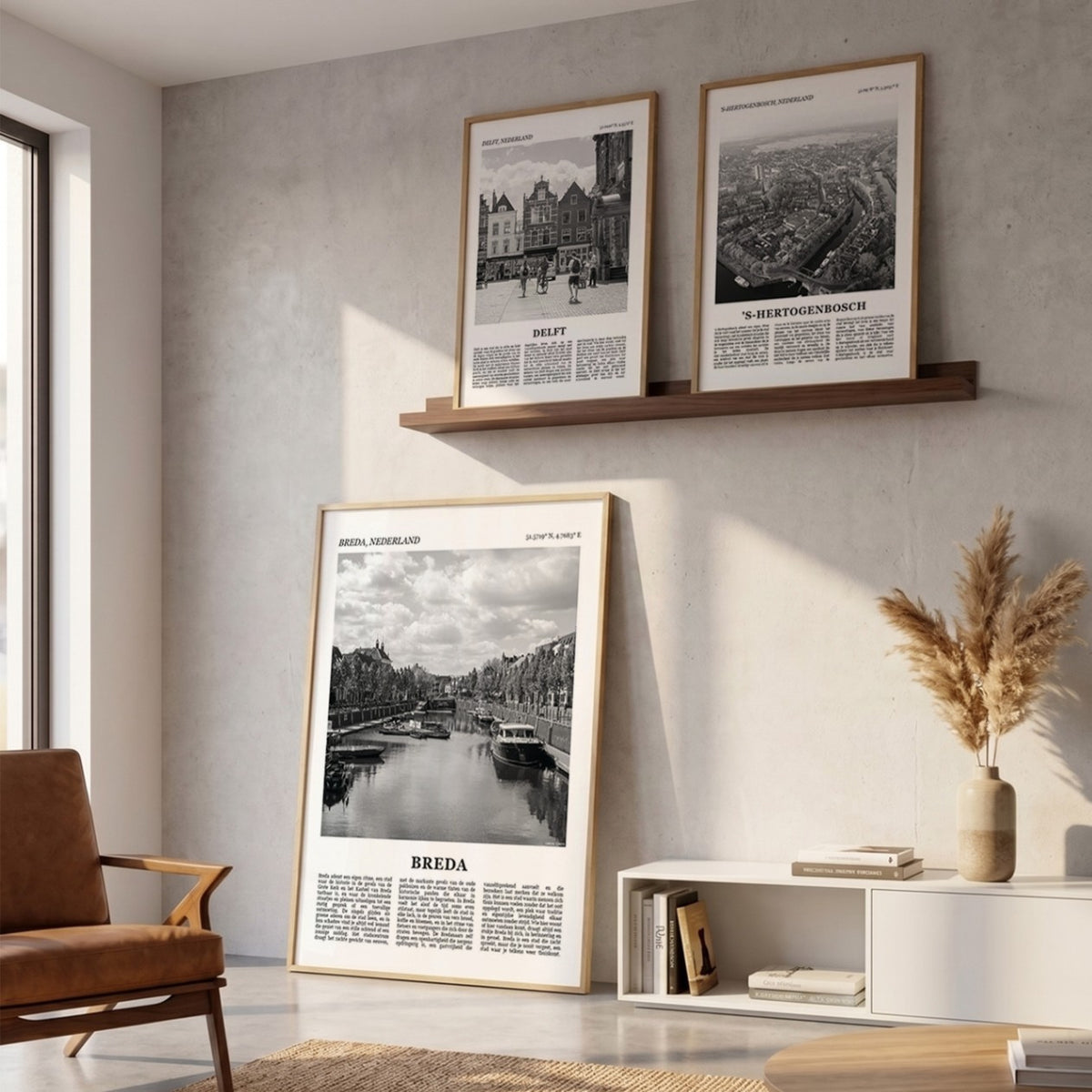 Drie ingelijste posters boven de bank in de woonkamer met Breda Fotoposter – Zwart-Wit in het groot