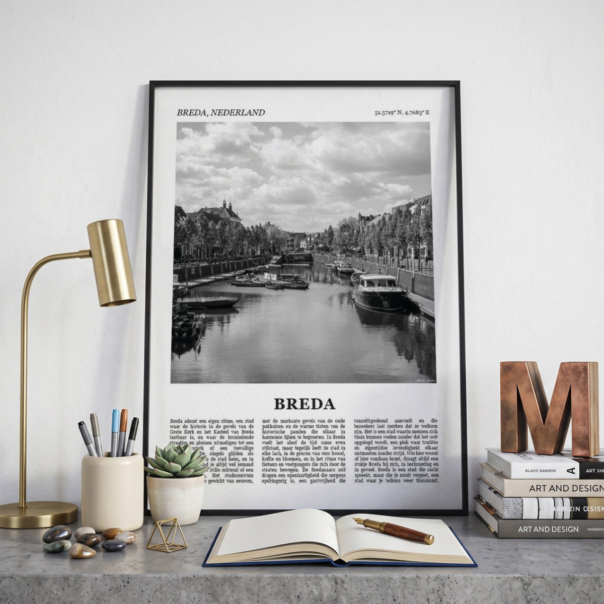Ingelijste Breda Fotoposter – Zwart-Wit op een bureau in zwarte fotolijst