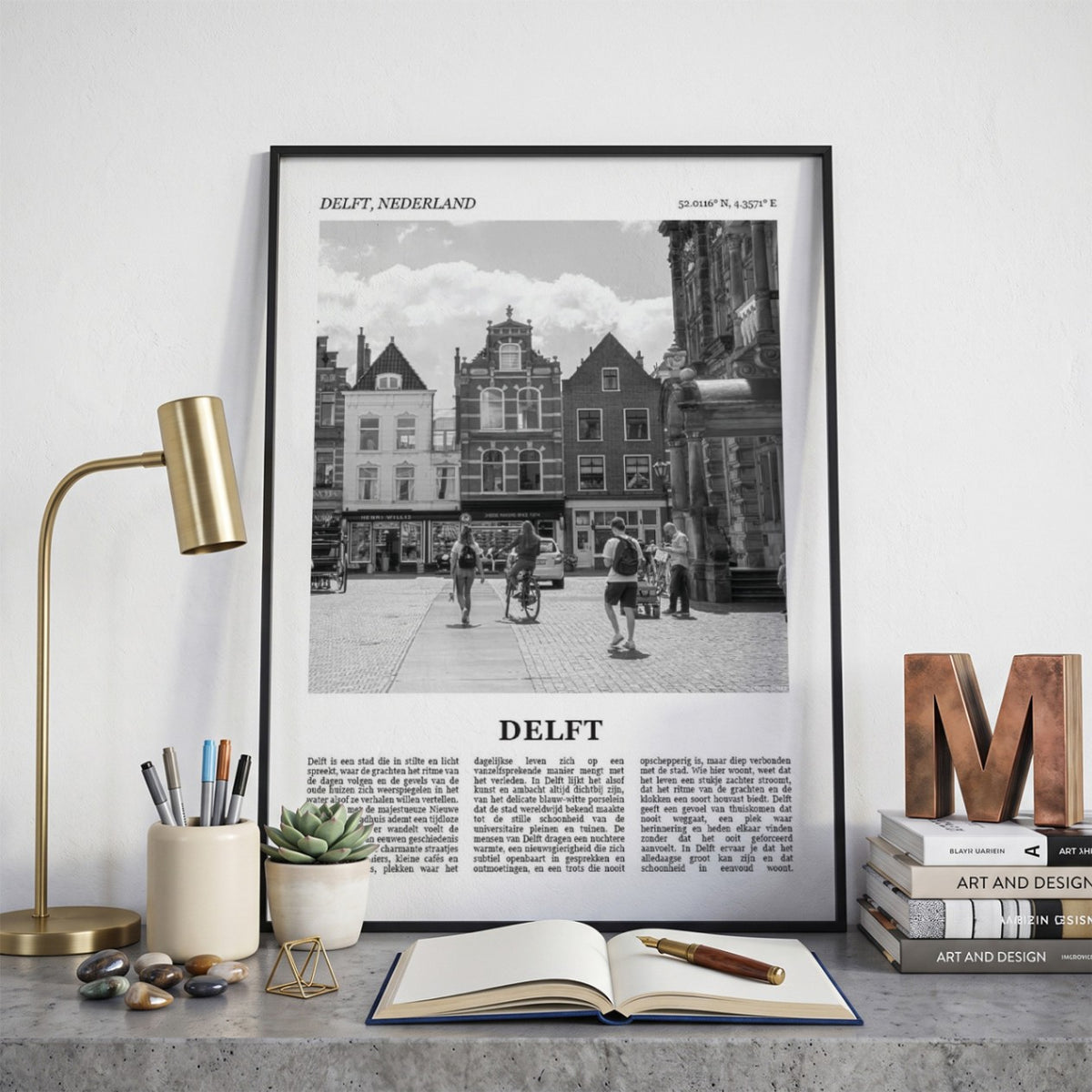 Ingelijste Delft Fotoposter – Zwart-Wit op een bureau in zwarte fotolijst