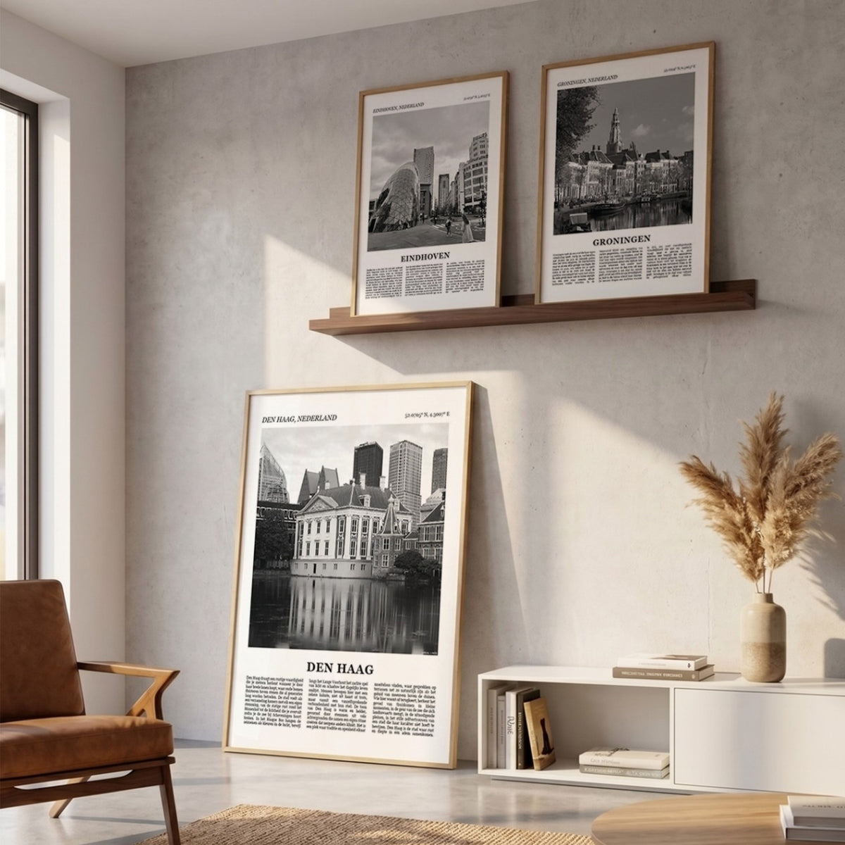 Drie ingelijste posters boven de bank in de woonkamer met Den Haag Fotoposter – Zwart-Wit in het groot