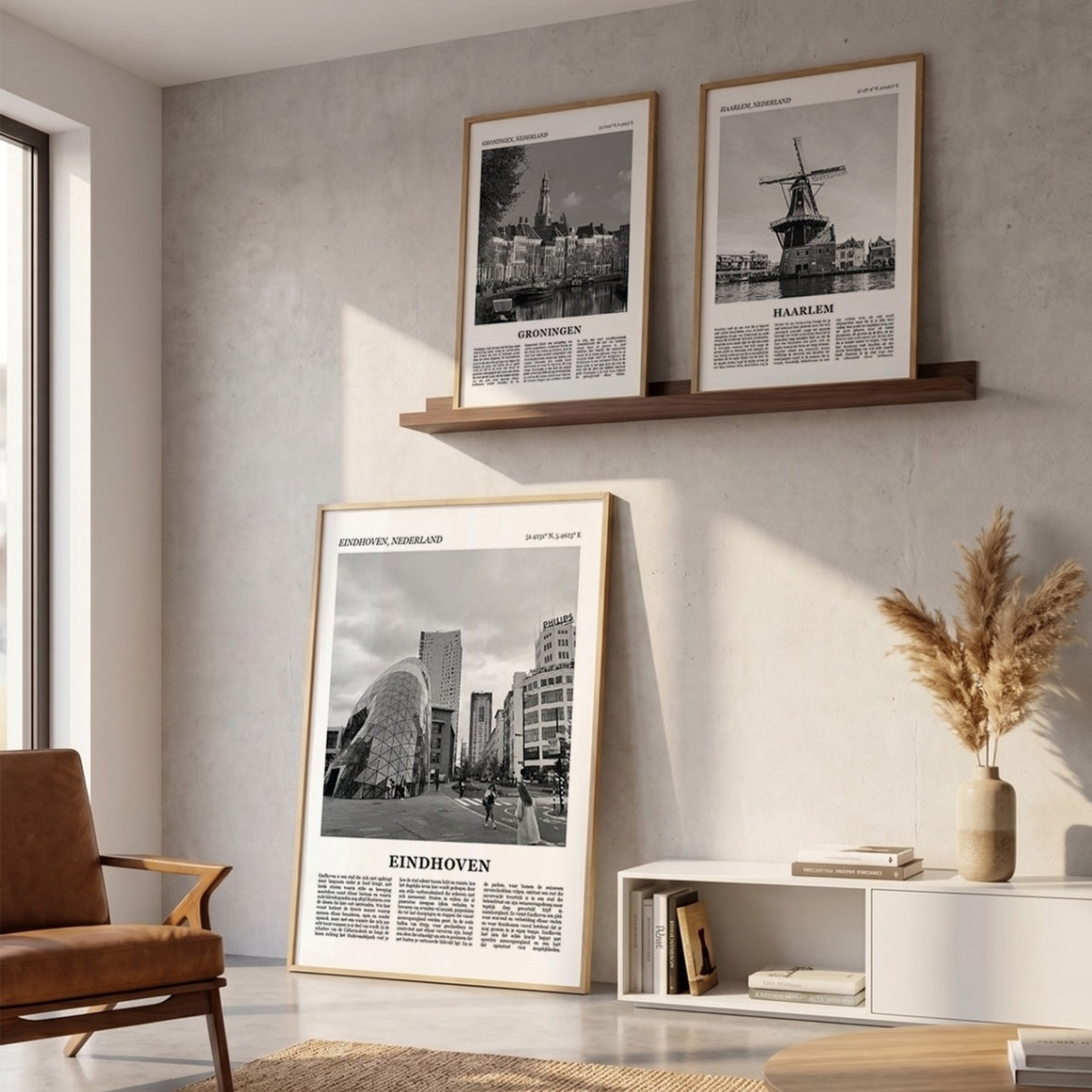 Drie ingelijste posters boven de bank in de woonkamer met Eindhoven Fotoposter – Zwart-Wit in het groot