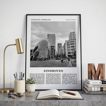 Ingelijste Eindhoven Fotoposter – Zwart-Wit op een bureau in zwarte fotolijst