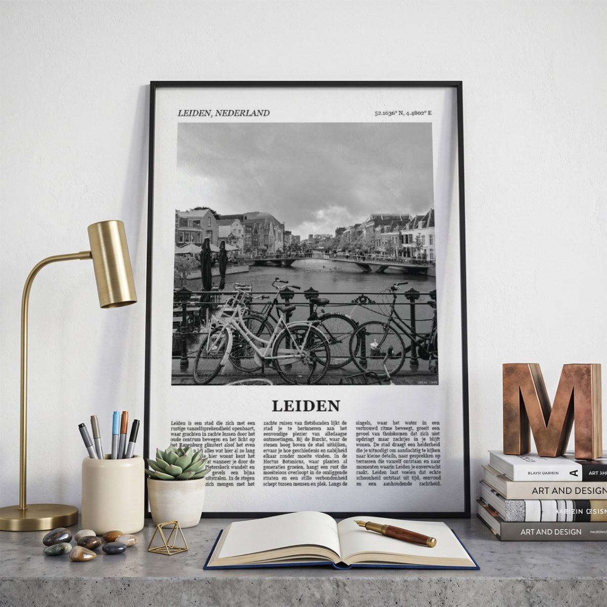 Ingelijste Leiden Fotoposter – Zwart-Wit op een bureau in zwarte fotolijst