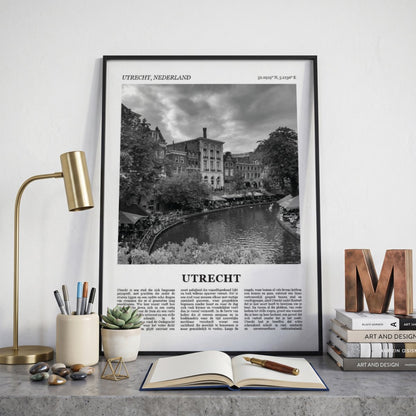 Ingelijste Utrecht Fotoposter – Zwart-Wit op een bureau in zwarte fotolijst